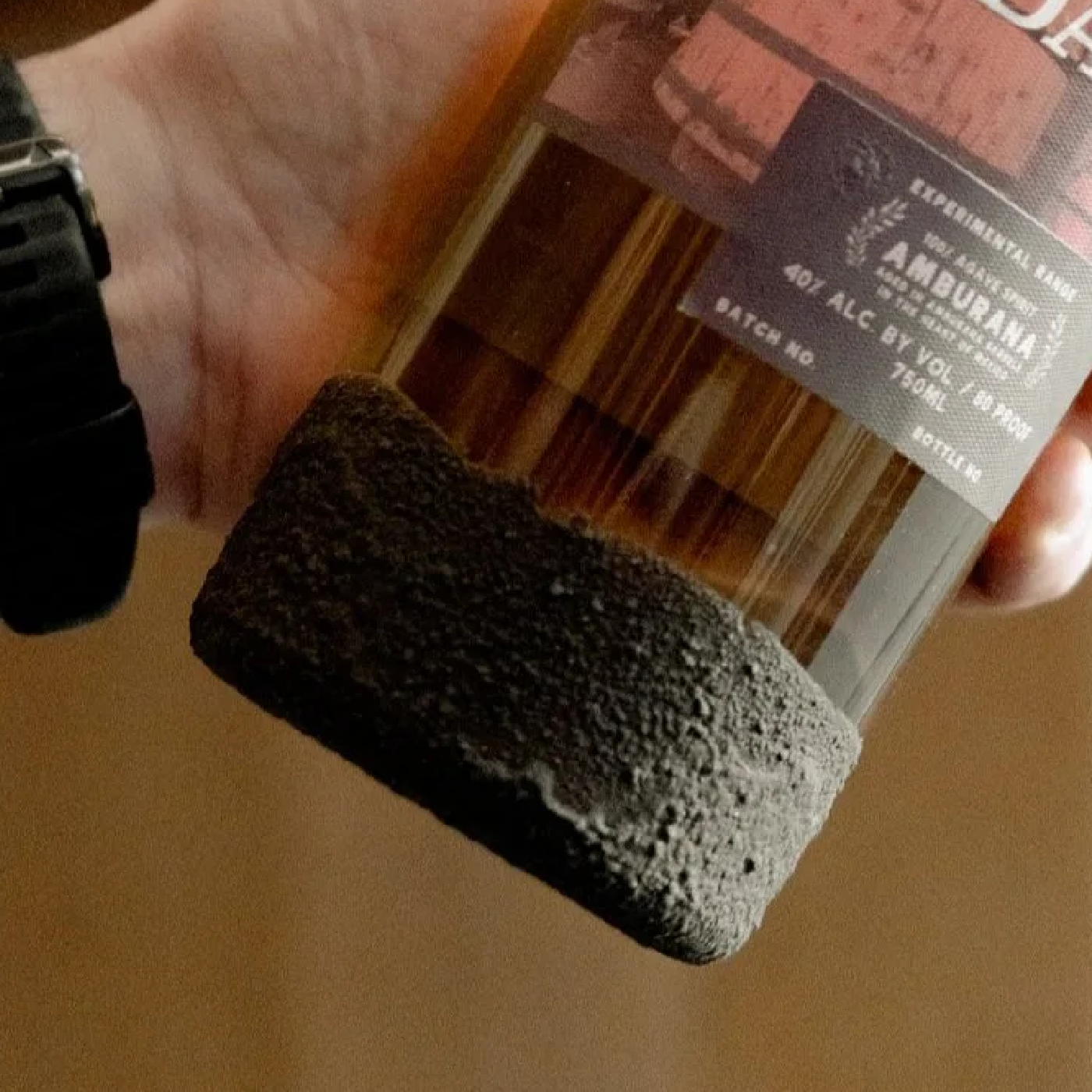 Close-up of the hand-dipped volcanic soil texture on the base of a Paladar bottle